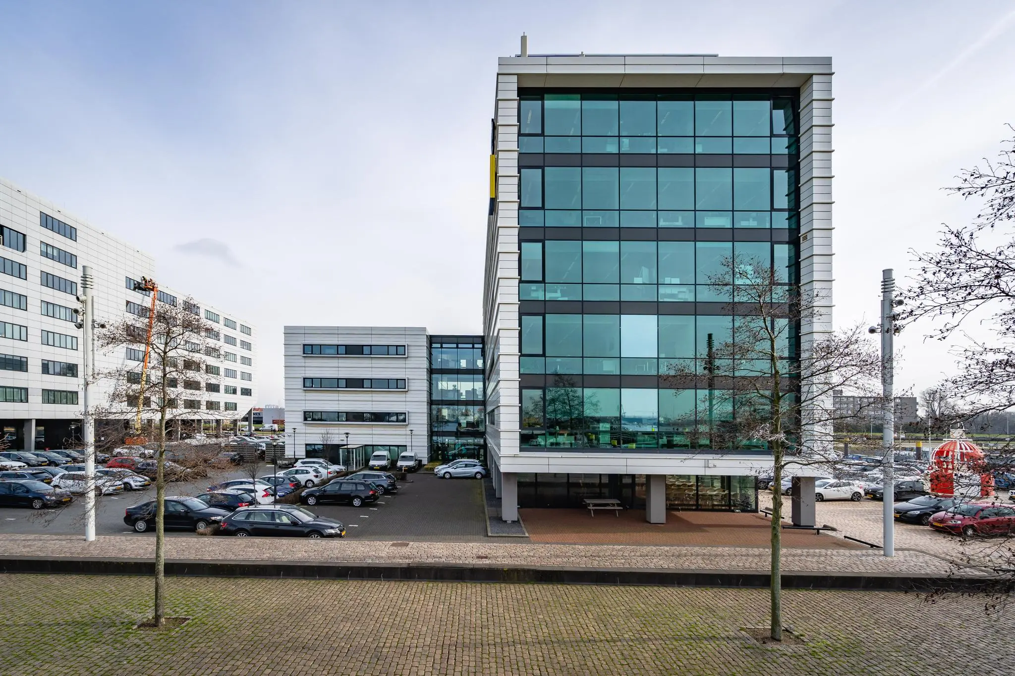 Modern kantoorgebouw aan de Waalhaven-Oostzijde met glazen gevel en omliggend parkeerterrein.
